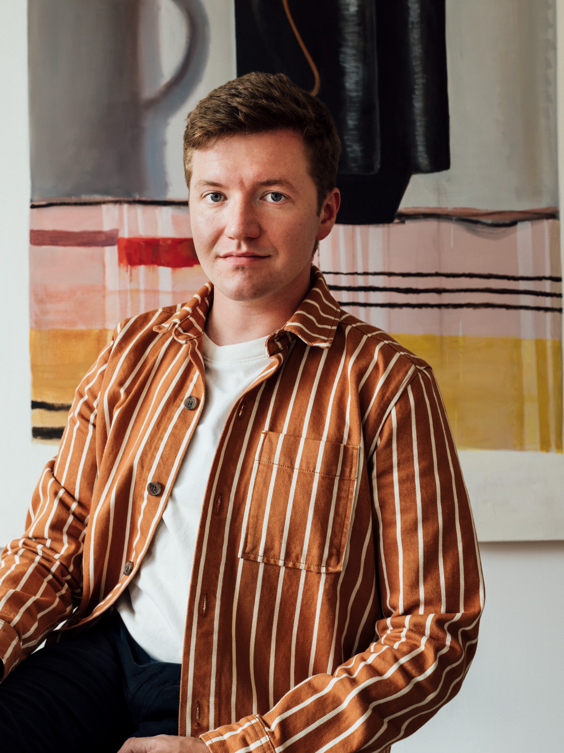 Portrait of Joseph Clark in front of an abstract artwork